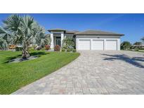 Beautiful home with a three car garage, landscaped yard and a paver driveway at 1801 Los Alamos Dr, Punta Gorda, FL 33950
