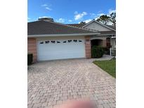 Inviting single-story home featuring a brick driveway and a spacious two-car garage at 2023 Lynx Run, North Port, FL 34288