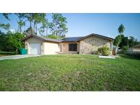 Charming home featuring stucco siding, stone accents, and a well-maintained lawn at 23273 Abeline Ave, Punta Gorda, FL 33980