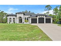 Stunning two-story home showcasing a manicured lawn and three-car garage at 3393 S Haberland Blvd, North Port, FL 34288