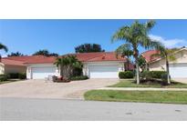 Charming villa with brick paved driveway and two-car garage, surrounded by lush landscaping and sunny skies at 3803 Albacete Cir # 64, Punta Gorda, FL 33950