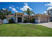 Charming single Gathering home featuring a well-manicured lawn and a two-car garage at 4294 Wooley Ave, North Port, FL 34287