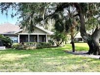 Charming single-story home with screened porch, mature trees, and well-maintained landscaping at 1431 Red Oak Ln, Port Charlotte, FL 33948