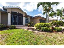Charming single-story home featuring a tile roof, manicured lawn, and a welcoming front entrance at 17150 Sarong Ln, Punta Gorda, FL 33955