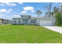 Beautiful single-Gathering home with a well-manicured lawn, blue door and a two-car garage at 2138 Blaser St, Punta Gorda, FL 33980
