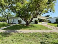 Charming single-story home featuring a carport and mature trees enhancing curb appeal at 21899 Cellini Ave, Port Charlotte, FL 33952