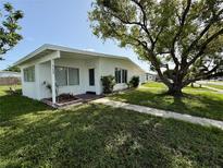 Charming single-story home featuring a lush lawn and mature shade trees at 21899 Cellini Ave, Port Charlotte, FL 33952
