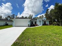 Charming single-story home with lush lawn, showcasing a clean, modern design with a two-car garage and light blue color palette at 2451 Waller Rd, North Port, FL 34288