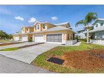 Inviting yellow townhomes featuring attached garages and well-maintained landscaping, offering a comfortable and stylish living environment at 25555 Heritage Lake Blvd # 27, Punta Gorda, FL 33983