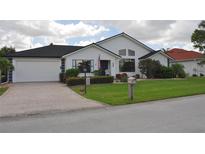 Charming single-story home with a brick driveway, well-manicured lawn and mature landscaping at 3724 Bordeaux Dr, Punta Gorda, FL 33950
