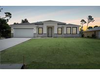 Charming single-story home featuring a well-manicured lawn, a two-car garage, and a welcoming entrance at 5018 Cillette Ave, North Port, FL 34288