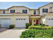Charming townhome featuring a red front door, garage, and well-maintained landscaping at 1273 Jonah Dr, North Port, FL 34289