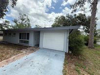 A single story home with a driveway and a one car garage and a light blue painted exterior at 2174 Schwalbe Way, Sarasota, FL 34235