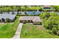 Inviting one-story home with mature landscaping, long driveway, and access to a canal for boating and waterside relaxation at 2467 Herron Ter, Port Charlotte, FL 33981