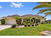 Beautiful single-story home with a well-manicured lawn, lush landscaping, and a two-car garage in a desirable neighborhood at 264 Rotonda N Blvd, Rotonda West, FL 33947