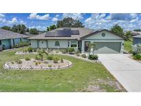 Charming one-story home with a well-manicured lawn, solar panels, and a cozy, welcoming entrance at 37 Pepe Ct, Punta Gorda, FL 33983