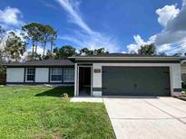 Charming single-story home featuring a well-maintained lawn and a two-car garage at 4854 Flamlau Ave, North Port, FL 34287