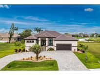 Stunning single-story home boasting a paver driveway, tile roof, and perfectly manicured landscaping at 609 Monaco Dr, Punta Gorda, FL 33950