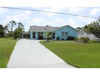 Charming single-story home with a well-maintained lawn, complemented by a long, patterned driveway at 6689 Gasparilla Pines Blvd, Englewood, FL 34224