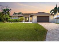 Beautiful single story home featuring a well-manicured lawn and neutral-toned exterior with an attached two-car garage at 8081 Dimstead St, Port Charlotte, FL 33981