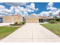 Charming single Gathering home featuring a wide driveway and beautifully landscaped front yard at 871 Columbia St, Port Charlotte, FL 33948