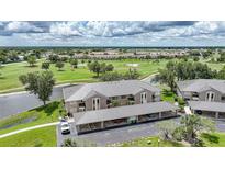 Beautiful aerial view of condos overlooking a golf course with covered parking and lush landscaping at 1375 Saxony Cir # 124, Punta Gorda, FL 33983