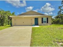 Charming single-story home featuring a well-manicured lawn and a two-car garage at 17344 York Ave, Port Charlotte, FL 33948