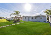 Charming single-story home featuring a lush green lawn and mature palm tree in a sunny neighborhood at 175 Rodgers Ne Ave, Port Charlotte, FL 33952