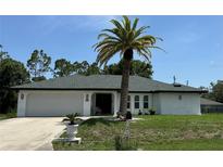 Charming single-story home featuring a well-maintained lawn and a stately palm tree at 21287 Birwood Ave, Port Charlotte, FL 33954