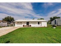 Charming single-story home featuring a well-manicured lawn and a bright white exterior at 3497 Cohoes St, Port Charlotte, FL 33952