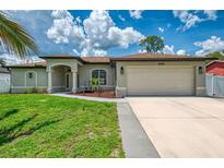 Charming single-story home with a well-manicured lawn, complemented by an attached two-car garage and neutral color palette at 4038 Corydon Ave, North Port, FL 34286