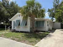 Charming single-story home featuring a mature palm and unique teal shutters at 420 W Olympia Ave, Punta Gorda, FL 33950