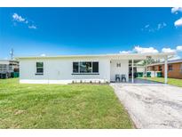 Charming single-story home with a well-maintained lawn and covered front porch, perfect for relaxing outdoors at 720 Dalton Blvd, Port Charlotte, FL 33952