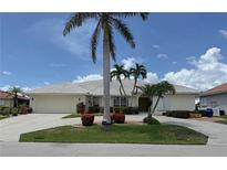 Charming single-story home with a well-manicured lawn, beautiful palms and a circular driveway at 1128 Rum Cay Ct, Punta Gorda, FL 33950