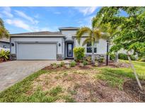 Beautiful one-story home with a two-car garage, well-manicured lawn, and stone accents at 16848 Canopy Garden Dr, Port Charlotte, FL 33953
