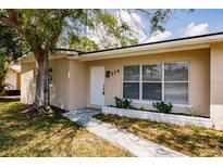 Charming single-story home featuring a well-maintained lawn and mature shade tree in front at 214 W Grace St, Punta Gorda, FL 33950