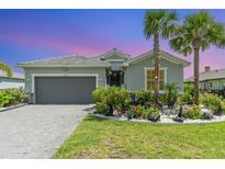 Beautiful one-story home featuring a well-maintained front yard with a two car garage and brick paver driveway at 24348 Nicobar Ln, Punta Gorda, FL 33955