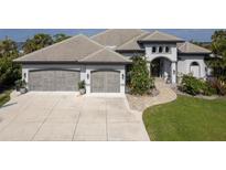 Beautiful home with a three-car garage and an arched entryway and large driveway at 25462 Shore Dr, Punta Gorda, FL 33950