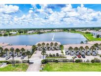 Scenic aerial view of waterfront condos featuring palm trees and ample parking spaces at 26310 Rampart Blvd # 504, Punta Gorda, FL 33983