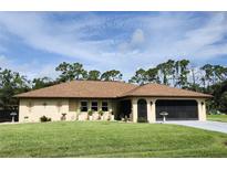 Charming home featuring a well-maintained lawn, a neutral color scheme, and a spacious screened garage at 319 Kindred Blvd, Port Charlotte, FL 33954
