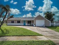 Charming single-story home with a blue front door, lush lawn, and attached one car garage at 3512 Nekoosa St, North Port, FL 34287