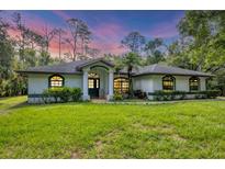 Charming single-story home with lush green lawn and well-maintained landscaping at 6514 N Biscayne Dr, North Port, FL 34291