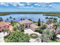 Stunning waterfront home with lush landscaping, circular driveway, and beautiful tile roof at 17509 Ohara Dr, Port Charlotte, FL 33948