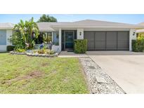 Charming single-story home featuring a well-manicured lawn, inviting entrance, and an attached two-car garage at 2141 Rio De Janeiro Ave, Punta Gorda, FL 33983