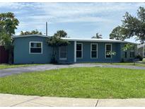 Charming single-story home with a well-maintained lawn and a circular driveway at 2513 Ambrose Ln, Port Charlotte, FL 33952