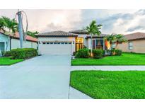 Charming single-story home featuring a well-manicured lawn, tile roof and attached two-car garage at 2712 Arugula Dr, North Port, FL 34289