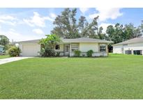 Charming single-story home with lush green lawn and mature landscaping, creating an inviting curb appeal at 4062 Blitzen Ter, North Port, FL 34287