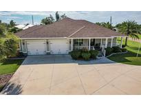 Beautiful single-story home featuring a two-car garage, covered front porch, manicured landscaping and spacious driveway at 437 South Dr, Punta Gorda, FL 33950