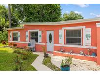 Charming coral-colored home with white trim, decorative shutters and walkway leading to the front door at 1027 Coral Ridge Dr, Punta Gorda, FL 33950
