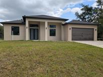Modern home featuring a neutral color scheme, double door entry, and a two-car garage at 136 Sequoyah Dr, Port Charlotte, FL 33954